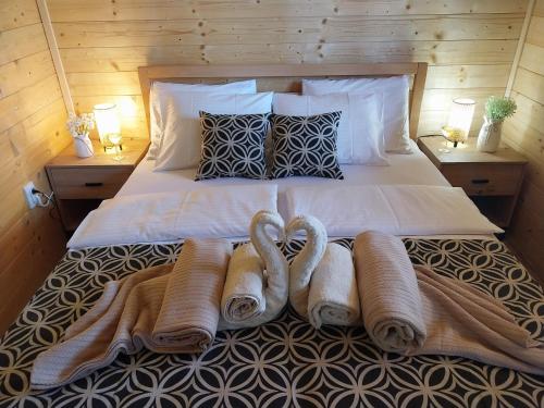 a bed with towels and pillows on top of it at Drvena Oaza in Gornja Toplica
