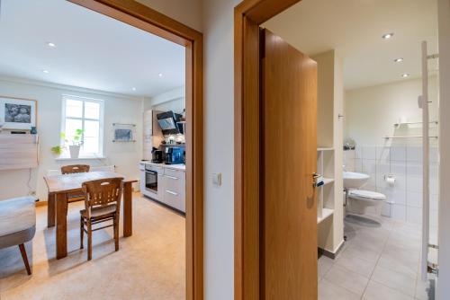 a kitchen and dining room with a table and a bathroom at Apartment AM MARKT Eisenach in Eisenach