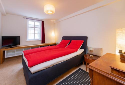 a bedroom with a bed with a red blanket at Apartment AM MARKT Eisenach in Eisenach