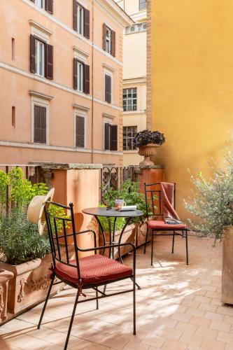 two chairs and a table on a patio with a building at Hotel Fori Imperiali in Rome