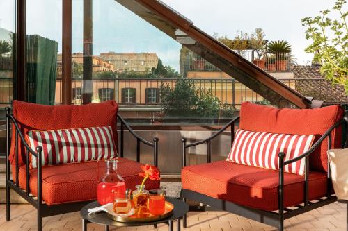 two chairs and a table on a balcony with a view at Hotel Fori Imperiali in Rome