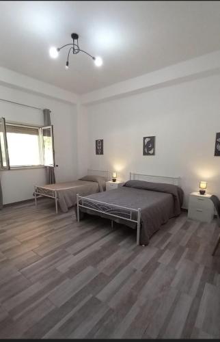 a bedroom with two beds and a wooden floor at Blu In in Palma di Montechiaro