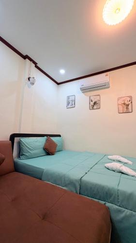two beds sitting next to each other in a room at Kohlibong forest house in Trang