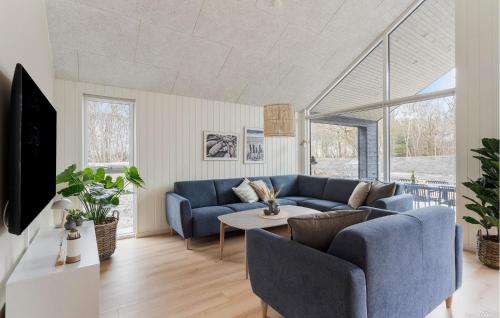 a living room with a blue couch and a table at Beautiful Home In Ringkøbing With Sauna in Ringkøbing
