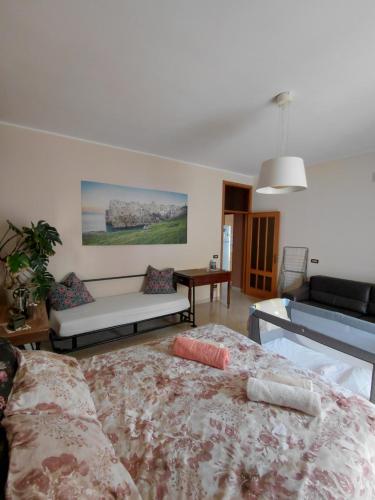 a bedroom with a bed and a couch in it at B&B familiare Arcadia Polignano in Polignano a Mare