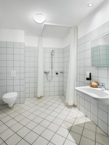 a bathroom with a tub and a toilet and a sink at Hunguest Hotel Aqua Sol in Hajdúszoboszló