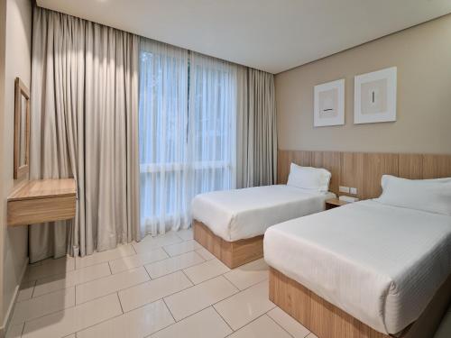 a hotel room with two beds and a window at Hamad - Salmiya -Family only in Kuwait