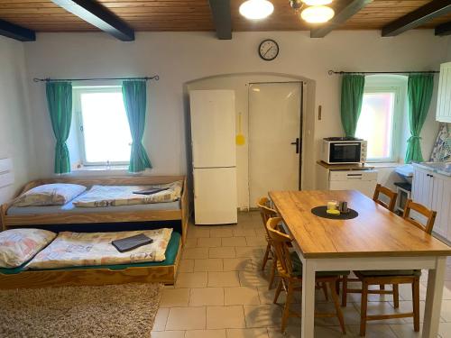 a room with two beds and a table and a kitchen at Stodola v zahradě in Vodňany