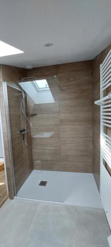 a bathroom with a shower with a glass door at Gîte des Tamaris Maison Chaleureuse proche Circuit in Arnage