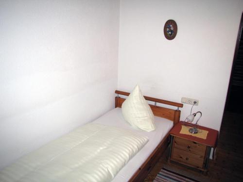 a small bedroom with a bed and a night stand at Pension Sydler in Bad Goisern