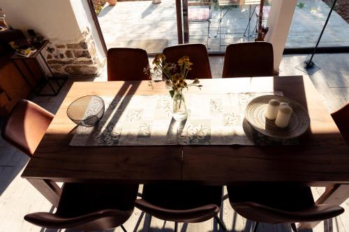 a wooden table with chairs and a vase of flowers on it at Casa Mila in Belish