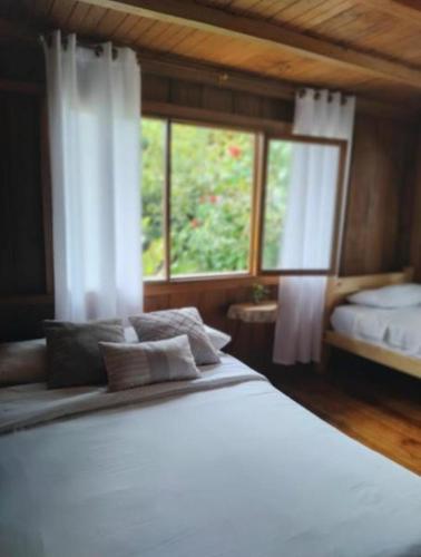 a bedroom with a large bed and a window at The Temple III, Mindo in Mindo