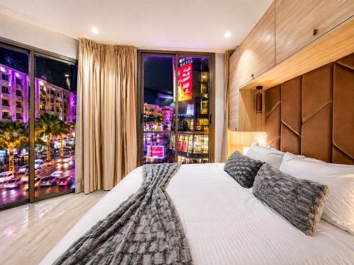 a bedroom with a large bed and a large window at ZEN Suites Hotel Massira in Casablanca