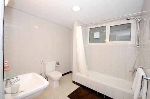 a bathroom with a toilet and a tub and a sink at Hamad - Salmiya -Family only in Kuwait