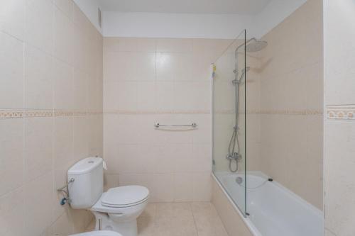 a white bathroom with a toilet and a shower at Brisa Caletillas in Punta Larga