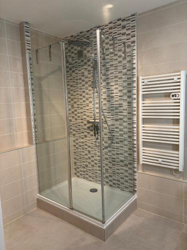 a shower with a glass door in a bathroom at L'essentiel in Hambach
