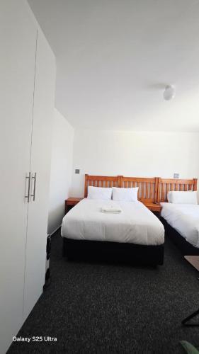 a bedroom with two beds with white sheets at MOHALALITOE B and B in Maseru
