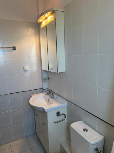 a bathroom with a sink and a toilet and a mirror at Captains View in Kefallonia