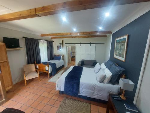 a bedroom with a large bed and a living room at Ben Nevis Guest House in Clocolan