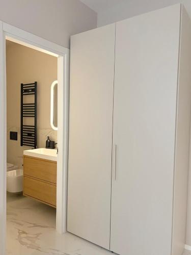 a bathroom with a white cabinet and a sink at Aura Suite in Parma