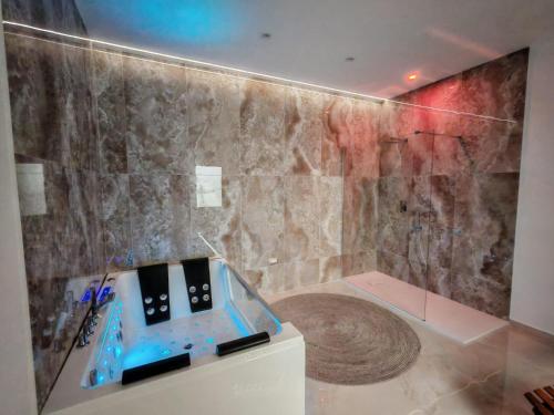 a bathroom with a shower with a stone wall at Suite Crystal Home with Jacuzzi in Trapani