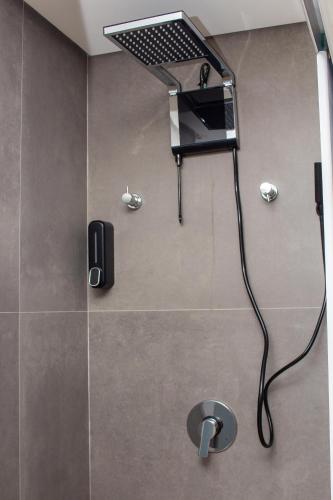 a bathroom with a shower with a laptop on the wall at Cabo Branco Flat Amsterdam in João Pessoa