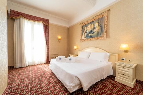 a hotel room with a bed and a window at Hotel Terme Roma in Abano Terme