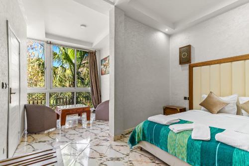 a bedroom with a bed and a desk and a window at Riad Rêve D'Ourika in Ourika