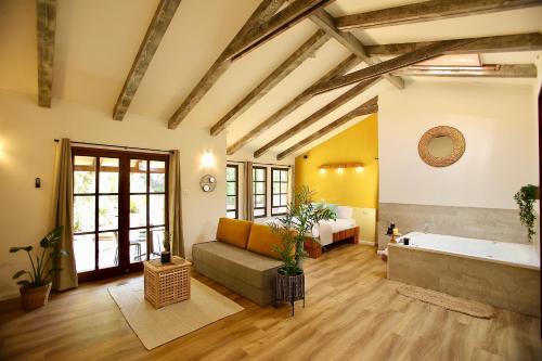 a large room with a tub and a bed and a couch at בקתות נומה in Moshav Ramot