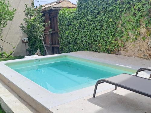 a swimming pool with a bench next to a fence at Casa de las Eras in Valdesimonte
