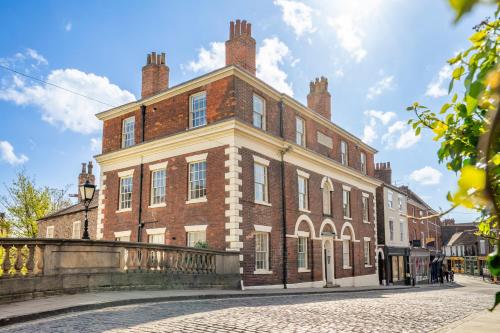 a large brick building on a cobblestone street at Walmgate Cottage in York