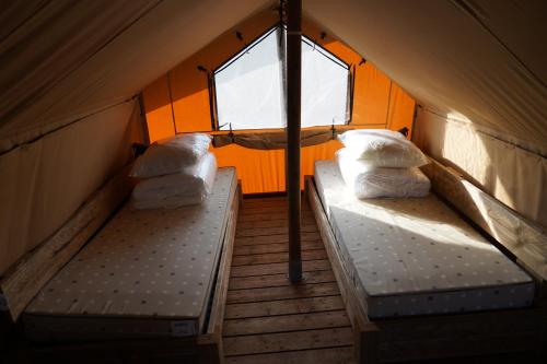 two beds in a tent with a window at F1 Ardennes Stay 5p Parking Bashfull in Amblève