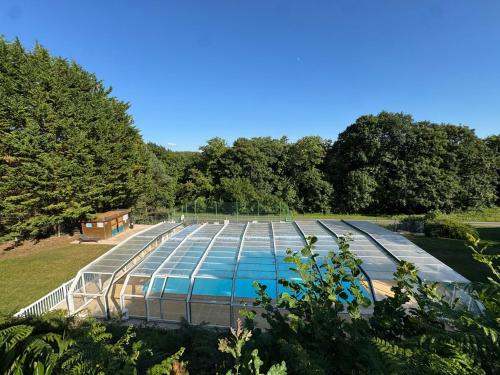 a glass building with a pool in a park at Bahia in Le Faulq