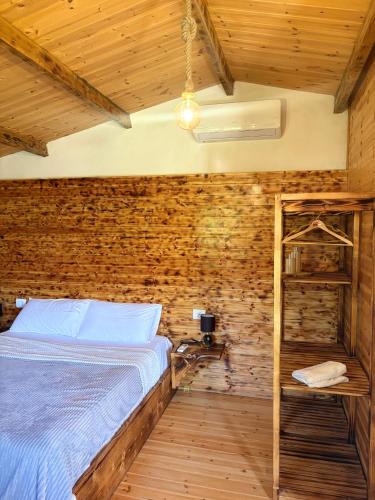 a bedroom with a bed and a brick wall at Sandri Nature Lodge in Karahaxh