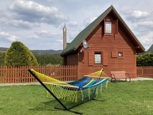 a hammock in a yard in front of a house at Domki Krótki Szpic in Istebna