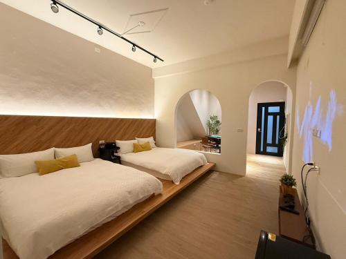 a bedroom with two beds and a tv in it at Tainan Little Day in Tainan