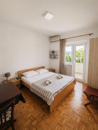 a bedroom with a large bed and a window at Apartmani Kasteljan 4, Stara Novalja in Stara Novalja