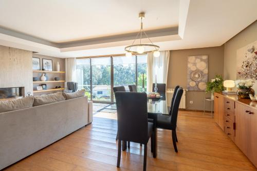 a living room with a couch and a table with chairs at Casa das Heras-Estadia com Hot Tub & Vale para 1 jantar in Avintes