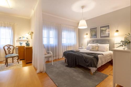 a bedroom with a bed and a table and a chair at Casa das Heras-Estadia com Hot Tub & Vale para 1 jantar in Avintes