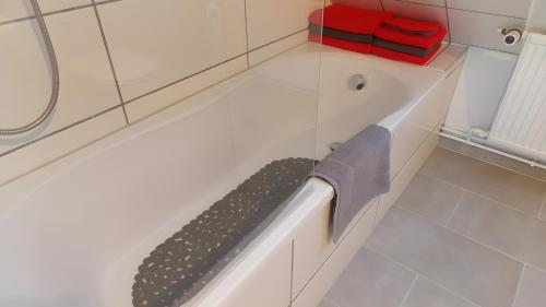 a bathroom with a bath tub with a black object in it at Ferienwohnung Mohnblume in Gerswalde