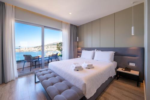 a bedroom with a large bed and a large window at Hotel Teuta in Sarandë