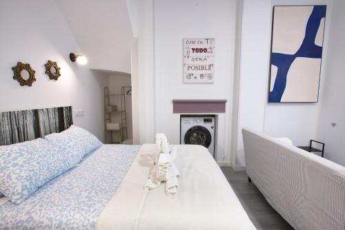 a white bedroom with a bed and a fireplace at Cuencaloft El 3 in Cuenca