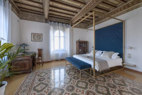 a bedroom with a canopy bed with a blue canopy bedvisor at Tenuta Il Poggio - Luxury B&B in Felegara