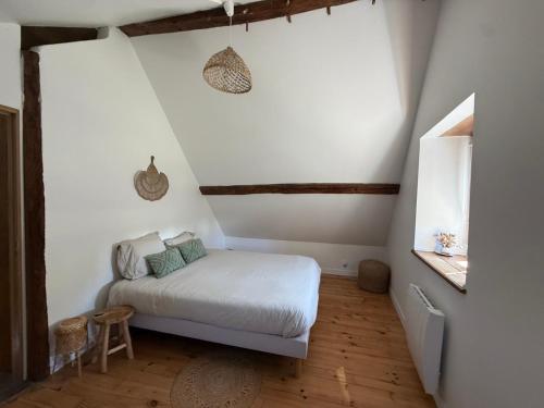 a small bedroom with a bed in a attic at Le Clos du Avre - Maison calme & jardin verdoyant in Breux-sur-Avre