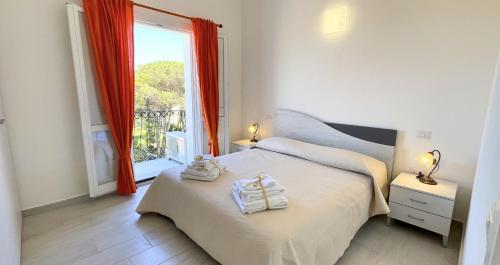 a bedroom with a bed and a large window at Dimora Mary - Vicino al mare in La Maddalena