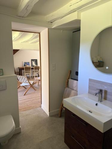 a bathroom with a sink and a mirror and a living room at Le Clos du Avre - Maison calme & jardin verdoyant in Breux-sur-Avre
