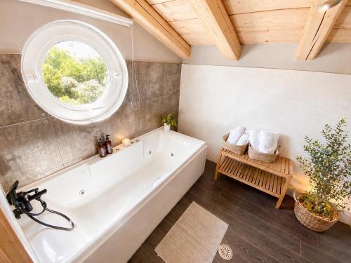 a bathroom with a white tub and a window at Le Blanc in Dassia