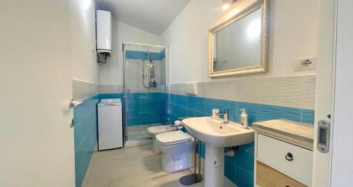 a bathroom with a sink and a toilet and a mirror at Dimora Mary - Vicino al mare in La Maddalena
