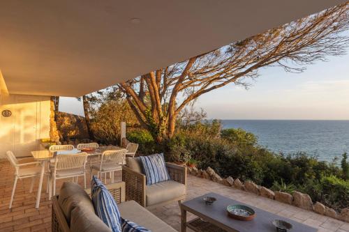 a patio with a table and chairs and the ocean at Refugio in Carvoeiro