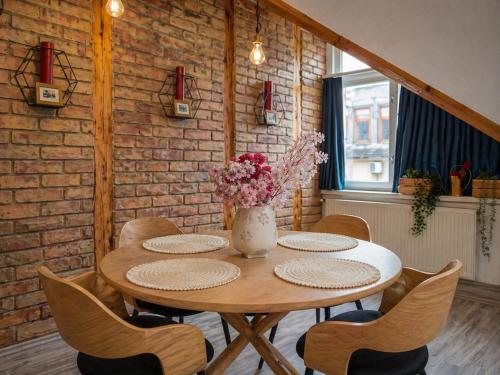 a table with chairs and a vase of flowers on it at ACME Apartments in Budapest